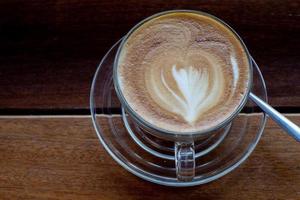 café cappuccino na velha mesa de madeira e grãos de café torrados - imagem foto