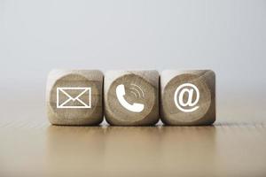 atendimento ao cliente e conceito de contato comercial, bloco de cubo de madeira que imprime carta de tela, endereço de e-mail telefônico e mensagem. foto