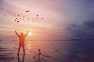 o fotógrafo está feliz à beira-mar e está feliz com sua fotografia. foto