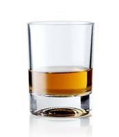 uísque escocês em um copo elegante em um fundo branco com reflexos. foto