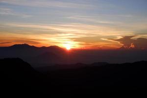 um cenário maravilhoso de um nascer do sol no topo da montanha na indonésia. bela paisagem de uma luz do nascer do sol da manhã. foto