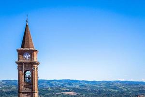 colinas do Piemonte na Itália com paisagem cênica, campo de vinha e céu azul. torre do sino goone à esquerda. foto