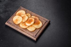 deliciosas panquecas frescas em uma tábua de madeira com açúcar foto