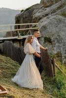 ensaio fotográfico de um casal apaixonado nas montanhas. a garota está vestida como uma noiva em um vestido de noiva. foto