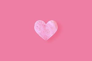 uma pedra em forma de coração em um fundo rosa. foto