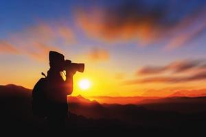 turistas de mulher tirando fotos em uma montanha no contexto do nascer do sol da manhã.