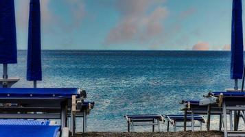 espreguiçadeiras na praia perto do mar em julho, em spotorno na riviera da ligúria ocidental foto