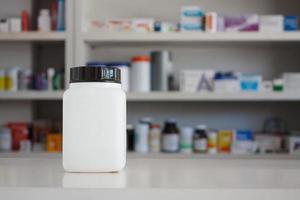 frasco de medicamento branco em branco com borrão prateleiras de drogas no fundo farmácia farmácia