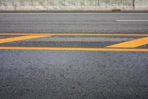 fundo de textura de estrada de asfalto com linha tracejada amarela foto