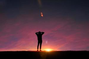 silhueta de homem adulto na montanha com um fundo romântico por do sol foto