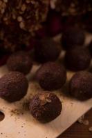 bolas de cacau, bolos de trufas de chocolate a bordo em fundo de madeira foto