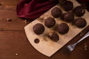 bolas de cacau, bolos de trufas de chocolate a bordo em fundo de madeira foto