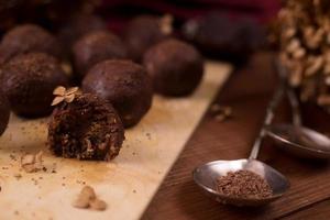 bolas de cacau, bolos de trufas de chocolate a bordo em fundo de madeira foto