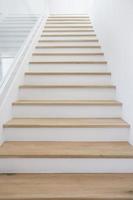 escadas de madeira com paredes brancas limpas. foto