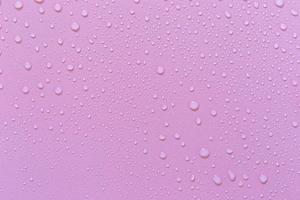 gotas de água em um fundo rosa. para como uma gota de fundo no produto. foto