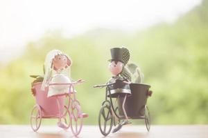 bonecas andando de bicicleta em madeira, bokeh de fundo foto
