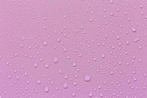 gotas de água em um fundo rosa. para como uma gota de fundo no produto. foto