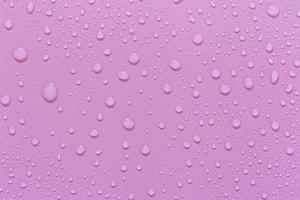 gotas de água em um fundo rosa. para como uma gota de fundo no produto. foto