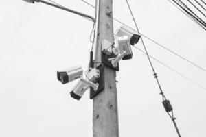 câmeras de vigilância presas a postes elétricos, tons preto e branco foto