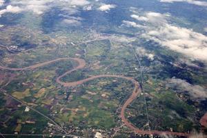 foto aérea da janela do avião, acima do solo e nuvem, campo verde sob as nuvens