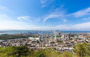 bandeira oscilando na frente da vista panorâmica do horizonte moderno de cartagena perto do centro histórico da cidade e zona hoteleira foto