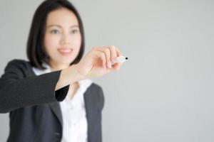 mulher de negócios desenho gráfico mostrando o crescimento do lucro na tela virtual. empresária asiática isolada no fundo branco de terno. foto