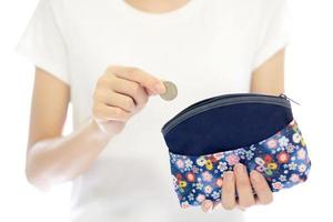 mãos segurando uma moeda britânica e bolsa de dinheiro pequena foto