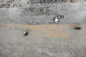 os mestres colocam pedras de pavimentação. conserto de calçada. vista aérea dos trabalhadores da estrada. foto