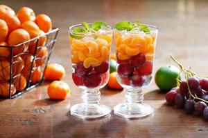 bebidas de dieta de desintoxicação refrescantes de vidro de frutas misturadas em fundo de madeira, água de infusão, conceito saudável foto
