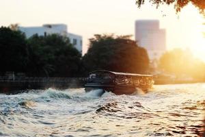 um barco tradicional na cidade do rio no fundo do pôr do sol, tom de cor dramática foto