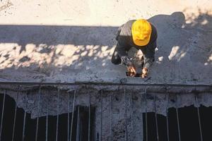 arquiteto ou engenheiro civil com capacete no canteiro de obras, verificando o cronograma no computador tablet foto