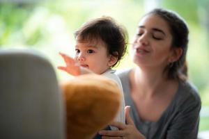 jovem mãe e filho bebê estão felizes em casa, conceito de família de infância com mãe caucasiana e garotinho, estilo de vida de cuidados com recém-nascidos foto