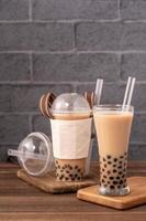 comida para viagem com conceito de item descartável popular taiwan bebida chá de leite bolha com copo de plástico e canudo no fundo da mesa de madeira, close-up, copie o espaço foto