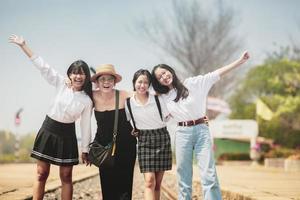 grupo de rosto de felicidade de mulher asiática em pé ao ar livre foto