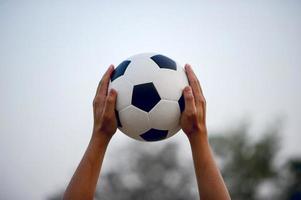 a imagem recortada de jogadores de esportes que pegam a bola e o campo de futebol. conceito de imagem esportiva. foto