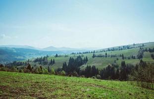 paisagem da colina com palheiros nas grandes montanhas na primavera em dia nublado foto