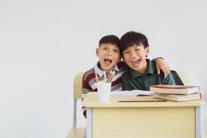 dois estudantes asiáticos felizes posando juntos em sala de aula