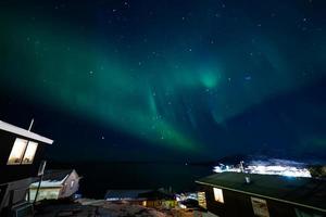 bela aurora luz do norte sobre a paisagem urbana da cidade. luzes do norte no sul kitaa qaqortoq groenlândia foto