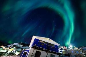 bela aurora luz do norte sobre a paisagem urbana da cidade. luzes do norte no sul kitaa qaqortoq groenlândia foto