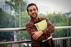 estudante segurando imagens de livros um jovem estudante universitário com livros perto do campus universitário foto