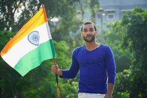 homem indiano com imagem ao ar livre de bandeira indiana foto