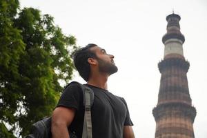 indiano jovem bonito no palácio histórico qutub minar viagens na imagem da índia foto