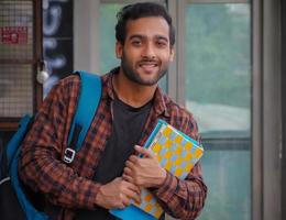 estudante universitário com bolsa e livros assistindo a câmera foto