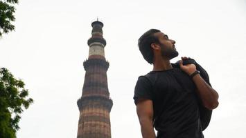 indiano jovem bonito no palácio histórico qutub minar viagens na imagem da índia foto