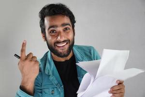 tendo papel e caneta homem asiático com fundo branco foto