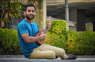 jovem bonito mulher tocando ukulele foto