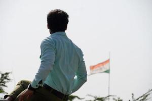 homem sentado na frente da bandeira nacional indiana e pensando foto