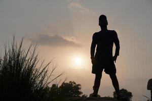 homem à noite perto do sol em pé foto