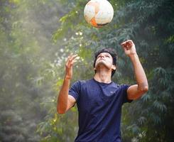 jovem jogador de futebol no campo de futebol imagem de homem indiano foto