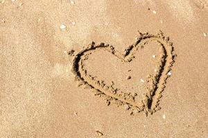 um desenho de um coração em uma areia amarela em um belo fundo de paisagem marinha. composição horizontal. foto